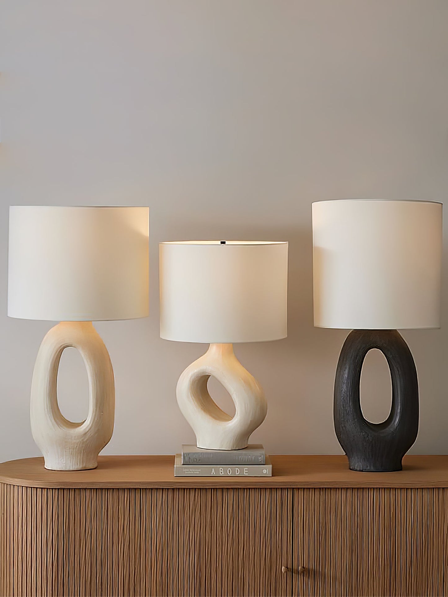 Based on the provided data:1. Core product: Table Lamp
2. Selling points: Sculptural design, ceramic base, available colors, fabric shade
3. New title: Sculptural Table Lamp | Ceramic Base | Beige, Black, White, Grey