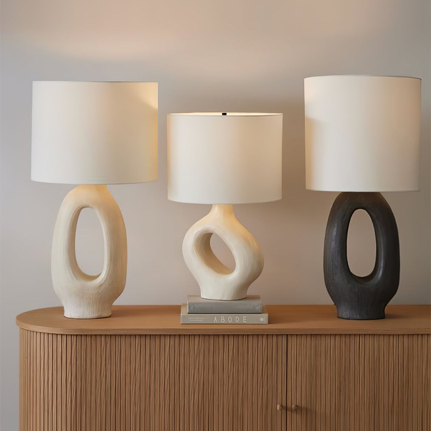 Based on the provided data:1. Core product: Table Lamp
2. Selling points: Sculptural design, ceramic base, available colors, fabric shade
3. New title: Sculptural Table Lamp | Ceramic Base | Beige, Black, White, Grey
